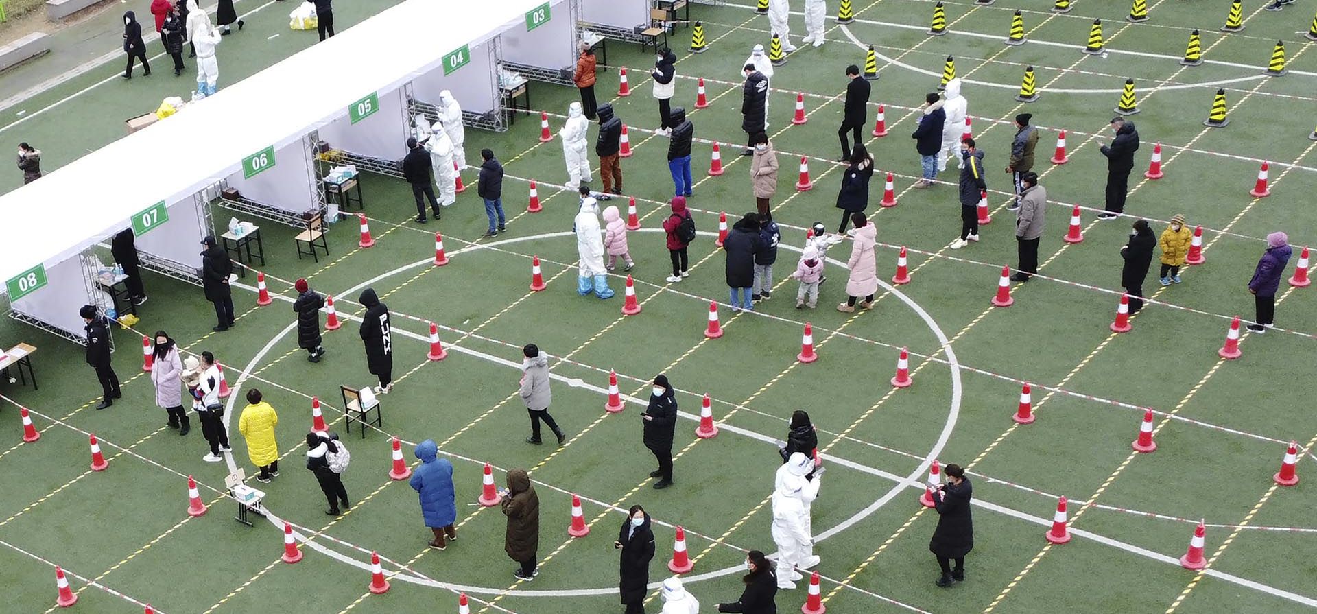 Un grupo de residentes hacen fila para una segunda ronda de pruebas de COVID-19 en el municipio de Tianjin, en el norte de China, el miércoles 12 de enero de 2022. La ciudad de Tianjin, en el norte de China, ordenó una segunda ronda de pruebas de COVID-19 a los 14 millones de residentes, luego del descubrimiento de 97 casos de la variante omicron durante las evaluaciones iniciales.