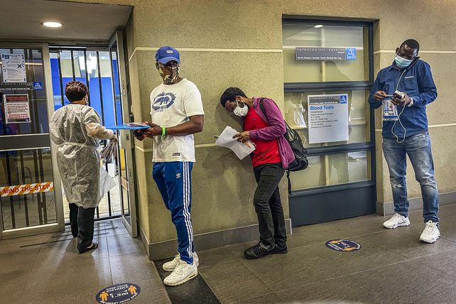 Sudafricanos esperan su turno para hacerse el test PCR en Johannesburg.