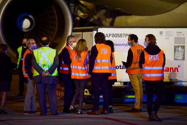 En la pista. El presidente (de perfil) en la noche de este jueves al lado del avión que transportó la carga.