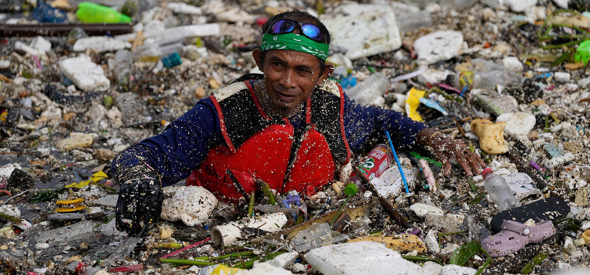 Un trabajador intenta limpiar una gran cantidad de basura y escombros arrastrados por las intensas lluvias monzónicas en el Canal de Agua Redentorista de la ciudad de Parañaque, Metro Manila, Filipinas, el martes 11 de agosto de 2026. (Foto AP/Aaron Favila)