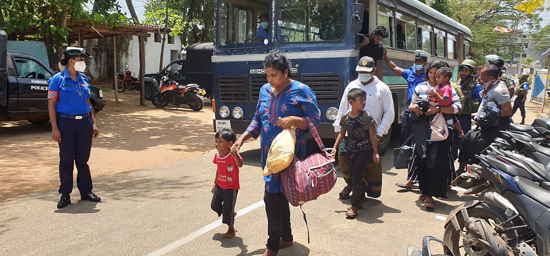 La policía lleva a un grupo de personas, que intentaban viajar ilegalmente a Australia, a una estación de policía en Trincomalee, Sri Lanka, el martes 24 de mayo de 2022. La marina de Sri Lanka dijo el martes que arrestó a 67 personas que cree que estaban tratando de viajar por mar a Australia ilegalmente.