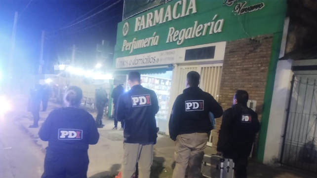 Personal de PDI en la farmacia que fue atacada anoche. 