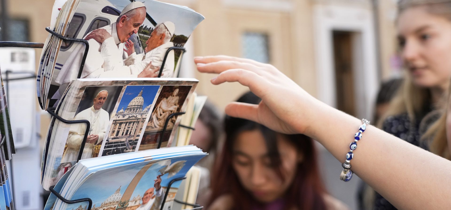 Turistas miran postales que muestran al papa Francisco y al papa emérito Benedicto XVI en Roma, cerca del Vaticano, el miércoles 28 de diciembre de 2022. La salud del papa emérito Benedicto XVI ha empeorado debido a su edad y los médicos controlan constantemente a los 95 años, el estado del anciano, dijo el miércoles el Vaticano. (Foto AP/Alessandra Tarantino