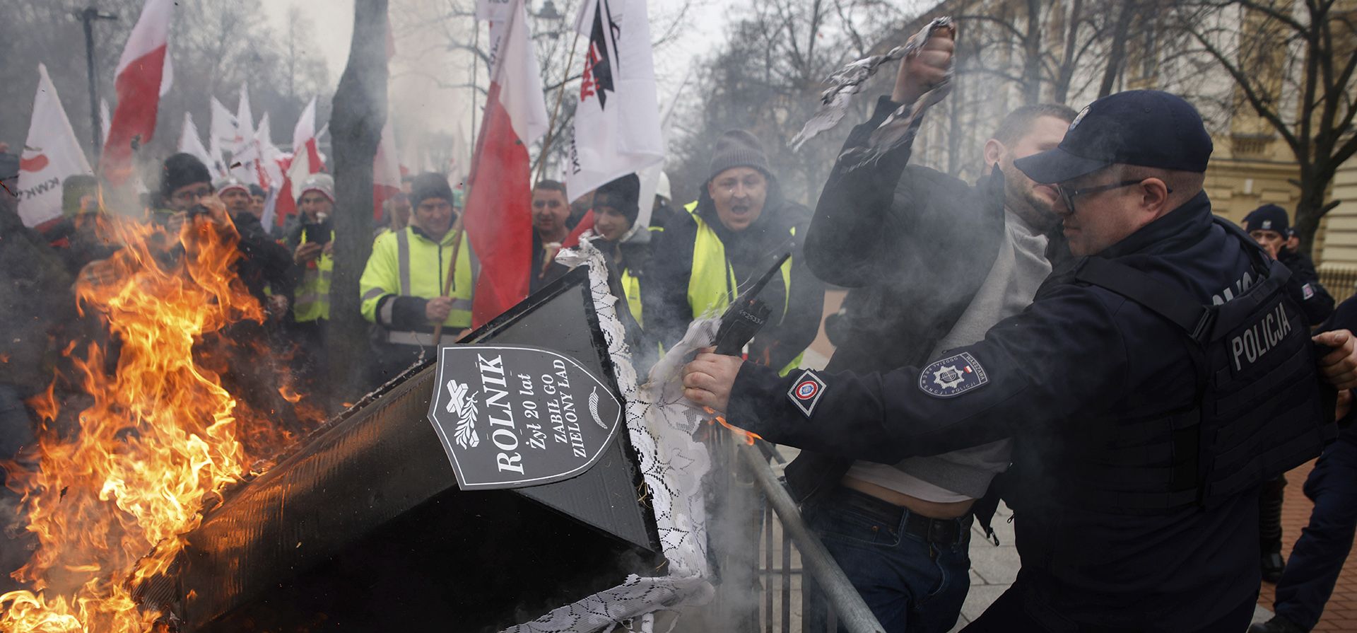 Un oficial de policía detiene a un manifestante junto a un ataúd en llamas durante una protesta en Varsovia, Polonia, el miércoles 6 de marzo de 2024. La protesta aumenta la presión sobre el gobierno, que exige que se cierre la frontera entre Polonia y Ucrania a las importaciones de alimentos y exige cambios en Políticas climáticas y agrícolas de la Unión Europea. (Foto AP/Michal Dyjuk)