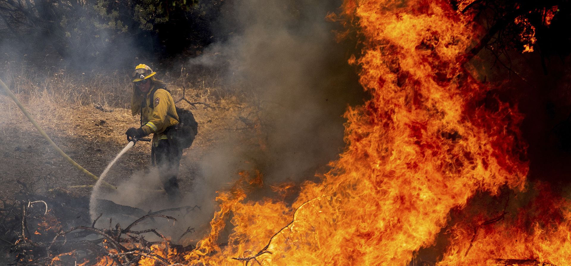 Un bombero rocía agua mientras lucha contra el incendio de Oak en el condado de Mariposa, California, el domingo 24 de julio de 2022.