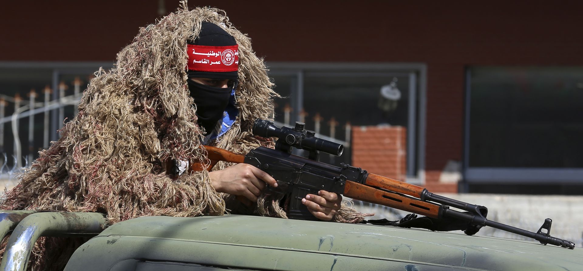 Un militante palestino del Frente Democrático para la Liberación de Palestina (FDLP) con camuflaje sostiene su rifle, durante una manifestación para conmemorar el 53° aniversario del movimiento en las calles de la ciudad de Gaza, el martes 22 de febrero de 2022.