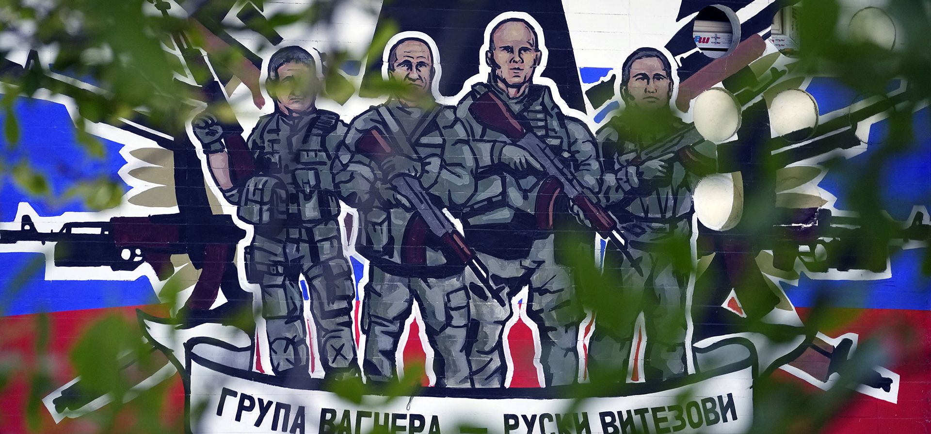 Un mural que representa a mercenarios del Grupo Wagner de Rusia que dice: