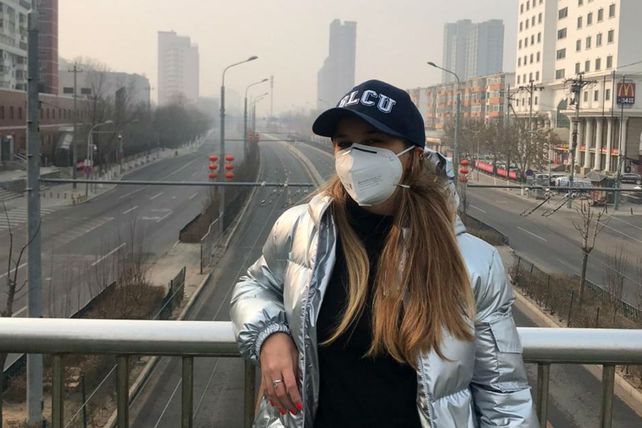 Bianca en un puente sobre una avenida principal desierta de Beijing.