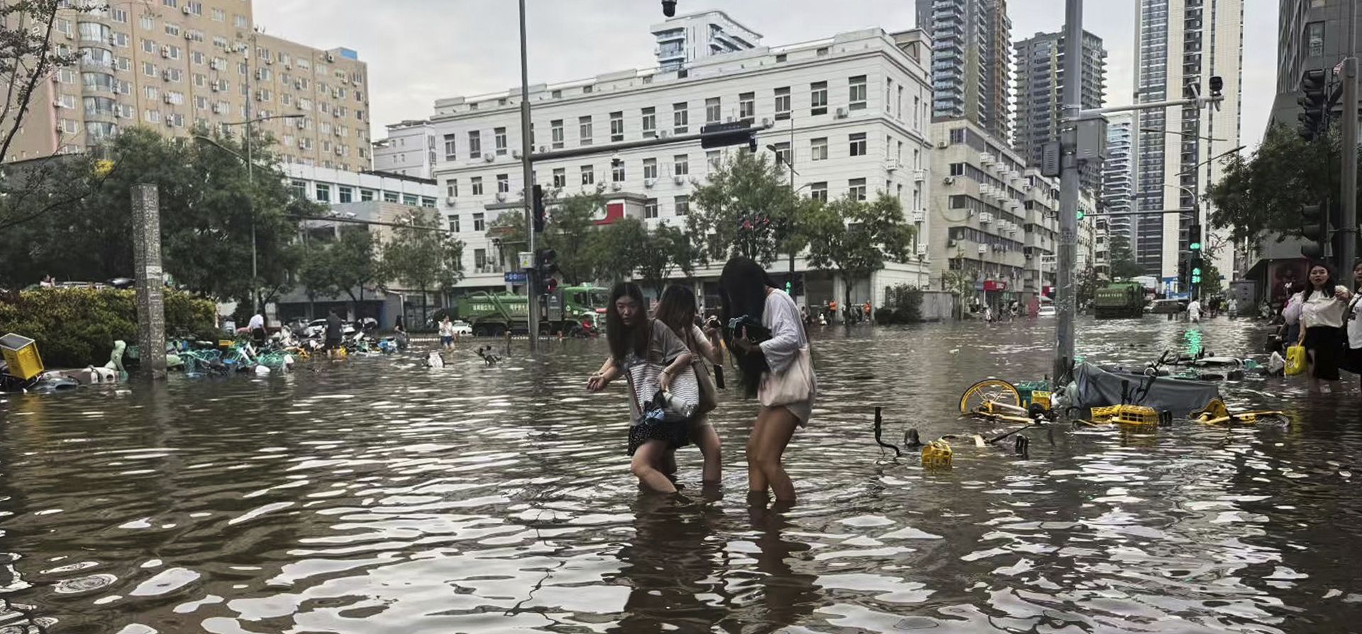 Mujeres cruzan una calle inundada tras las fuertes lluvias que llevaron al gobierno de la ciudad a ordenar la suspensión de negocios y actividades al aire libre, en Zhengzhou, provincia de Henan, en el centro de China, el jueves 7 de agosto de 2025. (Chinatopix vía AP) Mujeres cruzan una calle inundada tras las fuertes lluvias que llevaron al gobierno de la ciudad a ordenar la suspensión de negocios y actividades al aire libre, en Zhengzhou, provincia de Henan, en el centro de China, el jueves 7 de agosto de 2025. (Chinatopix vía AP)