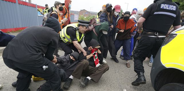 Un oficial de policía intenta detener a un activista pro palestino durante una protesta frente a la fábrica de Thales en Govan