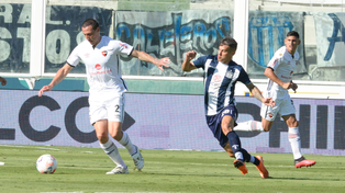 Cristian Lema sale desde el fondo perseguido por Carlos Auzqui. El defensor fue el mejor de la lepra en Córdoba.