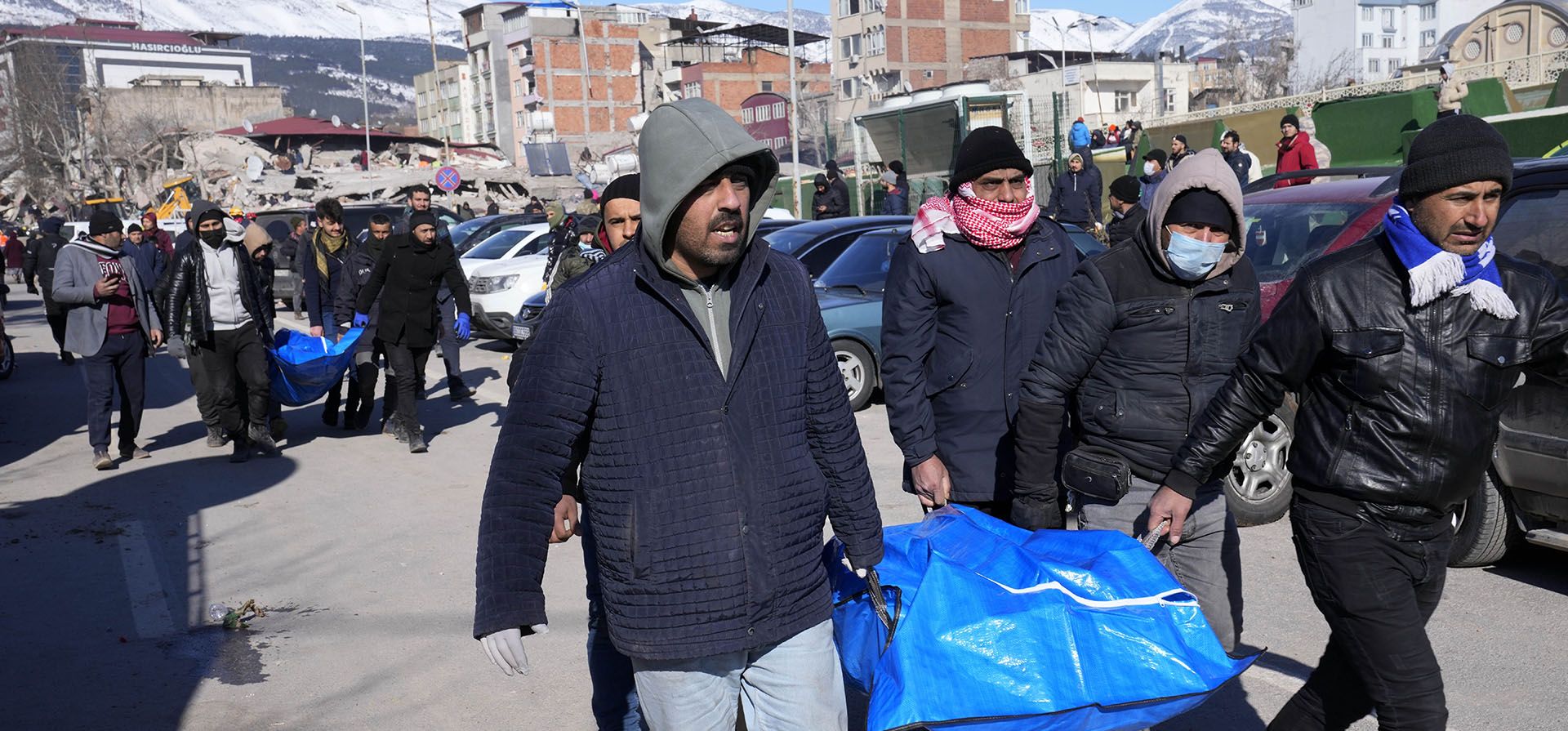 Personas cargan cadáveres de edificios derrumbados en Kahramanmaras, sur de Turquía, el miércoles 8 de febrero de 2023. Casi dos días después de que el terremoto de magnitud 7,8 azotara el sureste de Turquía y el norte de Siria, los equipos de rescate trabajan para sacar a más personas de los escombros de miles de construcciones afectadas por el terremoto. (Foto AP/Hussein Malla)
