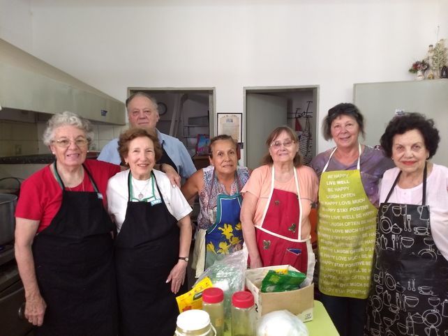 Manos que ayudan y cocinan tallarines con carne y verduras