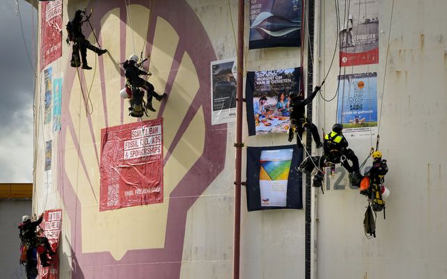 Activistas climáticos de Greenpeace que se cuelgan de un tanque de almacenamiento de combustible durante una protesta en una refinería de Shell en Rotterdam, Países Bajos, el lunes 4 de octubre de 2021.