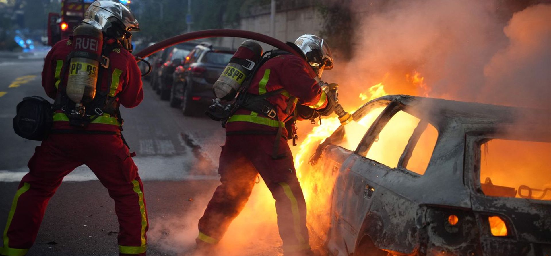 La muerte en Francia de un adolescente por disparos de la policía provocó indignación y disturbios en las calles. Dos bomberos trataban de sofocar el fuego en un vehículo, en Nanterre. Foto: ZAKARIA ABDELKAFI (AFP) La muerte en Francia de un adolescente por disparos de la policía provocó indignación y disturbios en las calles. Dos bomberos trataban de sofocar el fuego en un vehículo, en Nanterre. Foto: ZAKARIA ABDELKAFI (AFP)