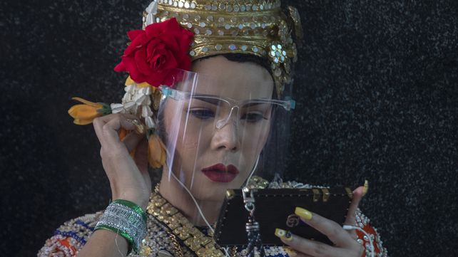Una bailarina clásica tailandesa usa su teléfono móvil durante un descanso en el Santuario Erawan en Bangkok