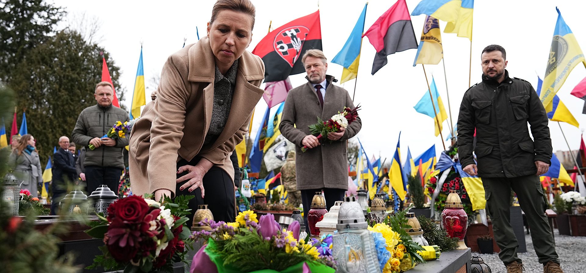 El presidente ucraniano, Volodymyr Zelenskyy, la primera ministra de Dinamarca, Mette Frederiksen, y su esposo Bo Tengberg, en el centro, depositan coronas de flores durante una ceremonia conmemorativa en el Campo de Marte en el cementerio Lychakiv en Lviv, Ucrania, el viernes 23 de febrero de 2024. (vía AP) El presidente ucraniano, Volodymyr Zelenskyy, la primera ministra de Dinamarca, Mette Frederiksen, y su esposo Bo Tengberg, en el centro, depositan coronas de flores durante una ceremonia conmemorativa en el Campo de Marte en el cementerio Lychakiv en Lviv, Ucrania, el viernes 23 de febrero de 2024. (vía AP)