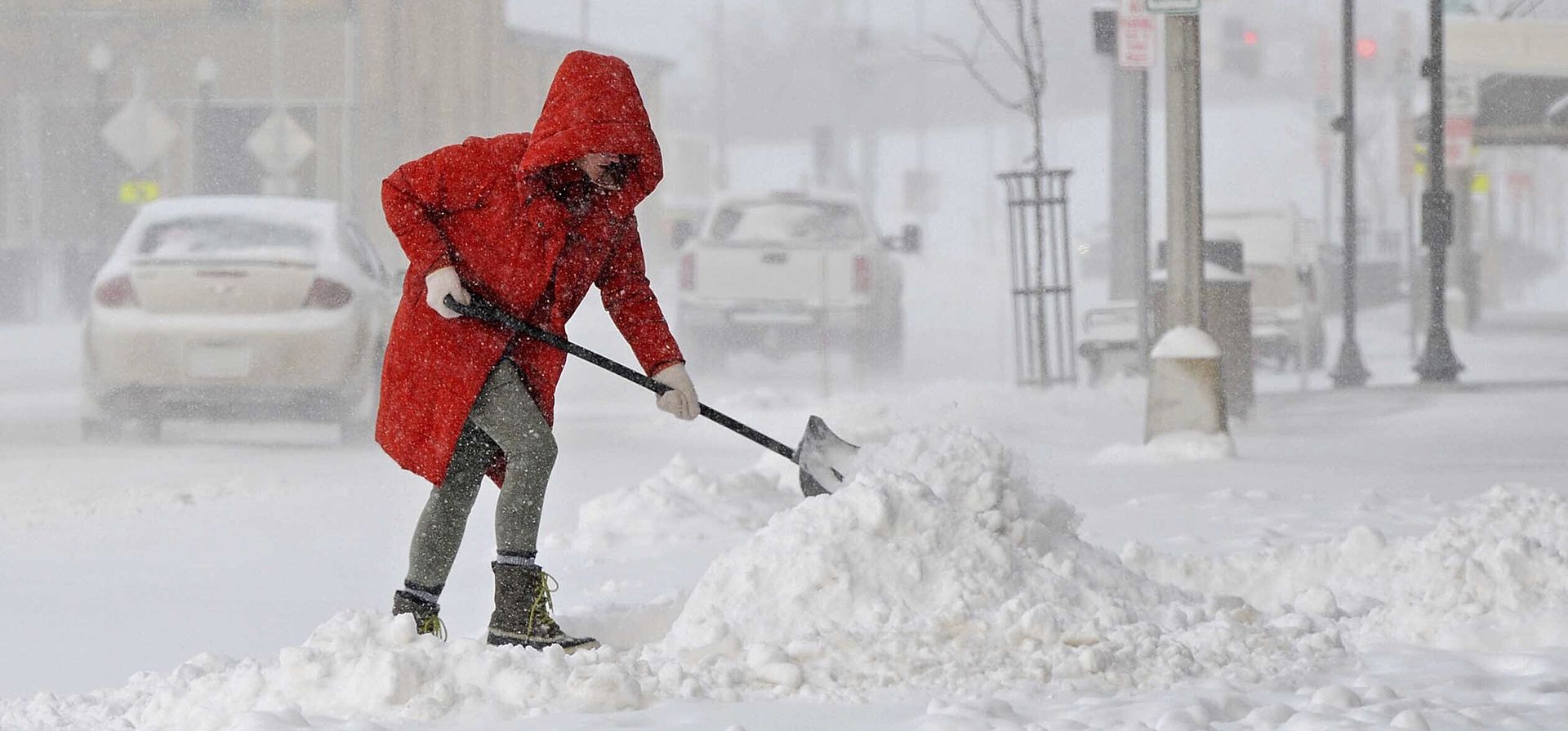 Una mujer limpia la nieve del frente de su negocio en Main Street en el centro de Mandan, N.D. La tormenta que dejó casi 4 pulgadas de nieve en el área de Bismarck Mandan, se acerca a una cantidad récord de nevadas (Tom Stromme/The Bismarck Tribune vía AP)