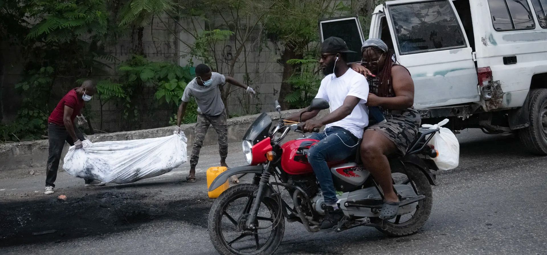 Puerto Príncipe, Haití. Dos hombres llevan el cuerpo de una persona que fue una de las varias personas asesinadas por una turba en Pétion-Ville por ser presuntos miembros del grupo armado Ti Makak, desmantelado hace unas semanas por la policía nacional. Fotografía: Johnson Sabin/EPA
