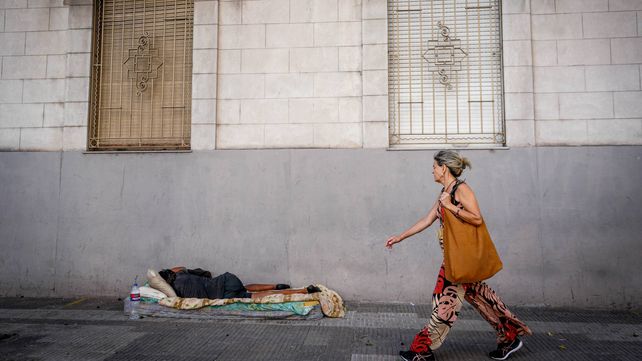 Una mujer camina y un hombre duerme en la calle Cochabamba casi San Martín