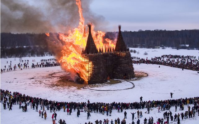 La gente observa cómo se quema una construcción de madera con forma de castillo como parte de las celebraciones del festival Maslenitsa (Shrovetide) en el parque de arte Nikola-Lenivets