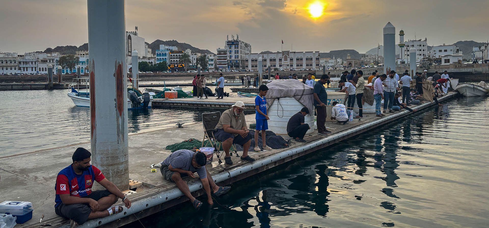 Varias personas pescan en un muelle cerca del paseo marítimo de Mutrah en Mascate, Omán, 26 de agosto de 2026. (Foto AP/Altaf Qadri, archivo)