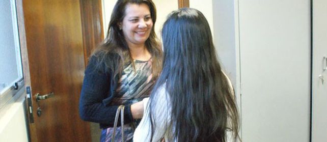 La chica (de espaldas) junto a una de sus cuidadoras en un instituto de la ciudad de Dourados