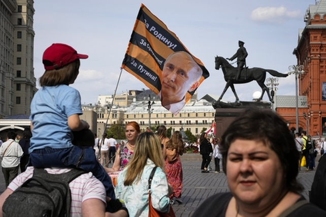 Una solitaria manifestante pro-Putin en la Plaza Roja de Moscú, en medio de la indiferencia general de los paseantes.