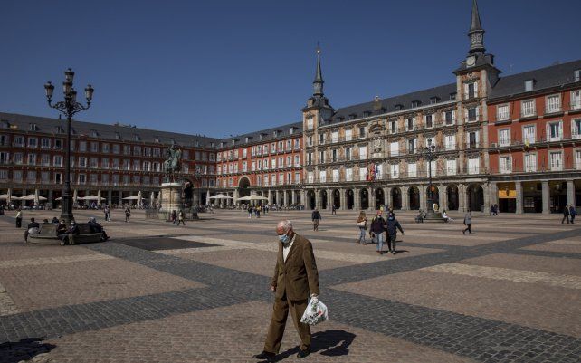 Un persona camina por la Plaza Mayor en el centro de Madrid, España. El país ibérico se ha comprometido a vacunar al 70% de su población adulta _o 33 millones de una población total de 47 millones_ para finales del verano. Hasta ahora, solo 1,8 millones, la mayoría de ellos residentes y trabajadores en hogares de ancianos, personal médico y otros trabajadores esenciales, han sido completamente vacunados.