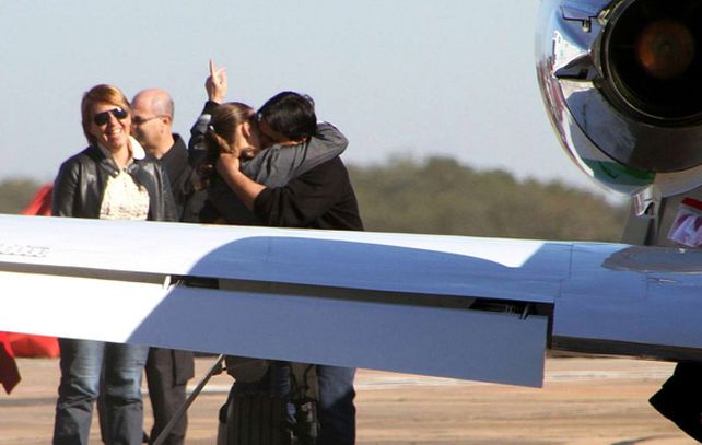 Los padres de la beba se abrazan en la pista del aeropuerto.