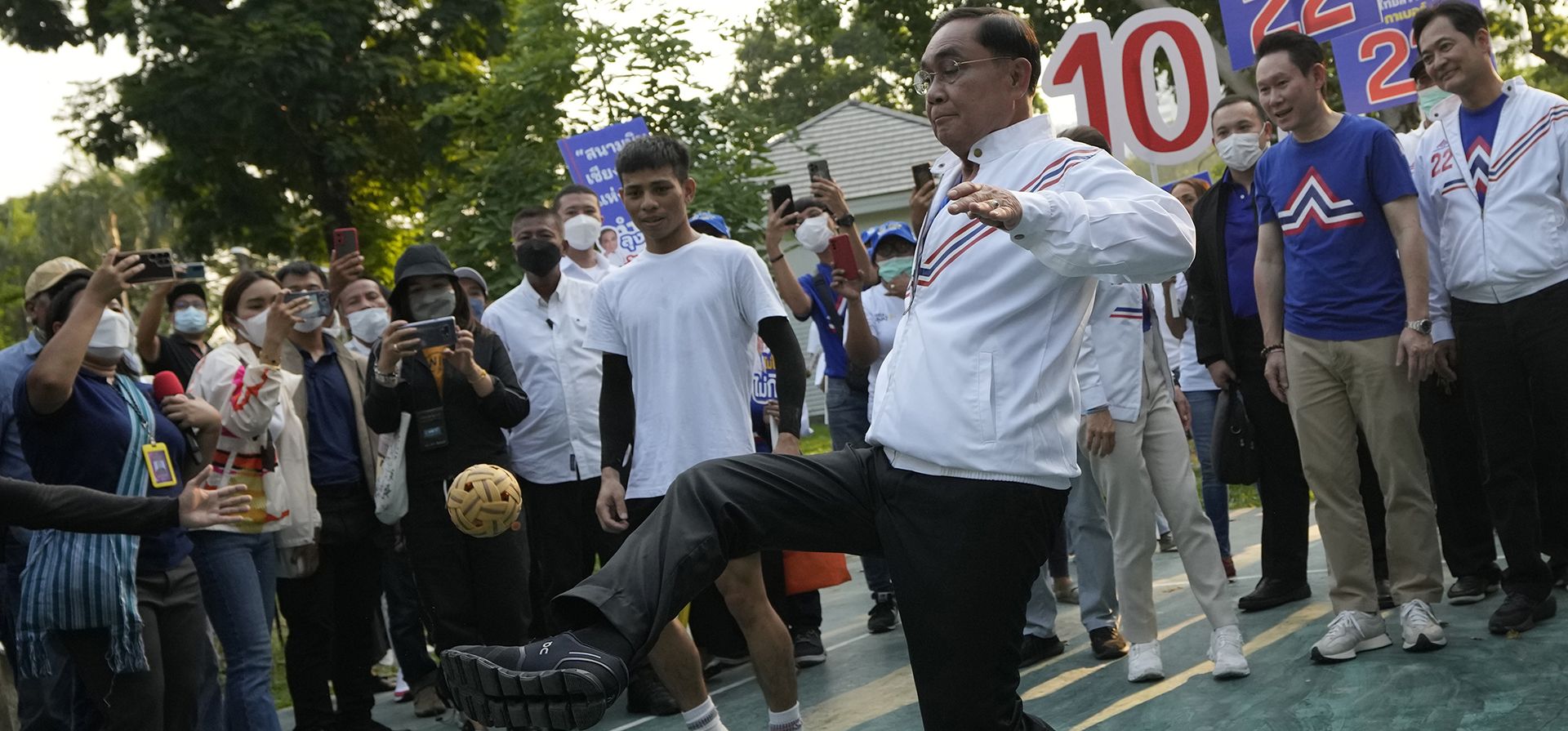 El primer ministro de Tailandia, Prayuth Chan-ocha, juega "sepak takraw", también conocido como patada de voleibol, durante una campaña electoral general en el Parque Lumpini en el centro de Bangkok el jueves 20 de abril de 2023. (Foto AP/Sakchai Lalit)