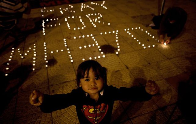 Velas en kuala lumpur. Un niña delante del homenaje al vuelo MH370.