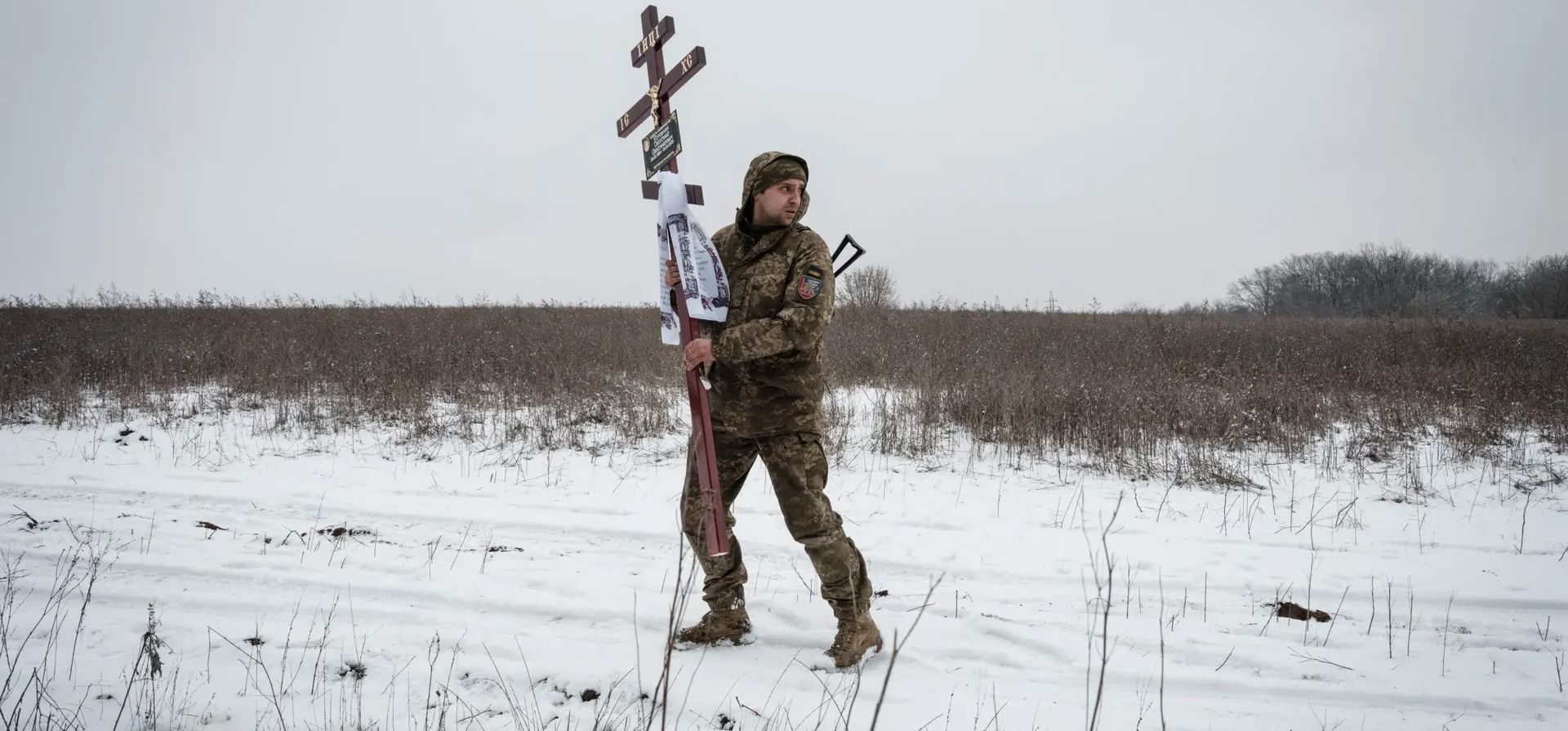 Oleksiy Storozh lleva una cruz para ser colocada en la tumba de su amigo Oleksandr Korovniy, del batallón Azov, que murió luchando en Bakhmut, Sloviansk, Ucrania. Fotografía: Yasuyoshi Chiba/AFP/Getty Images