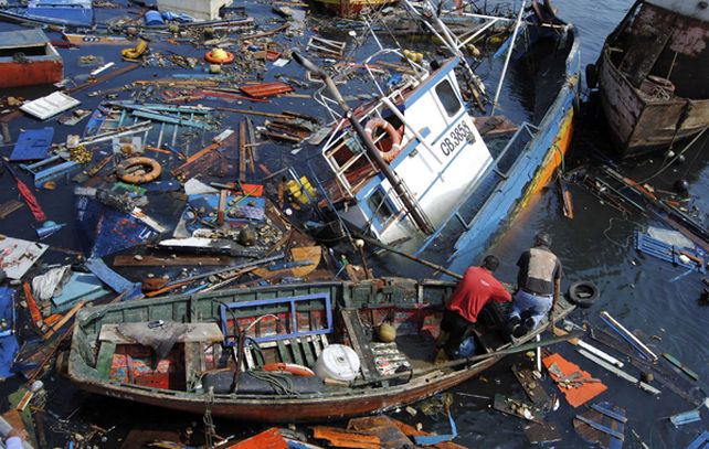 Un pescador en Iquique intenta abrirse paso entre los restos. El terremoto se sintió con potencia en las zonas de Arica