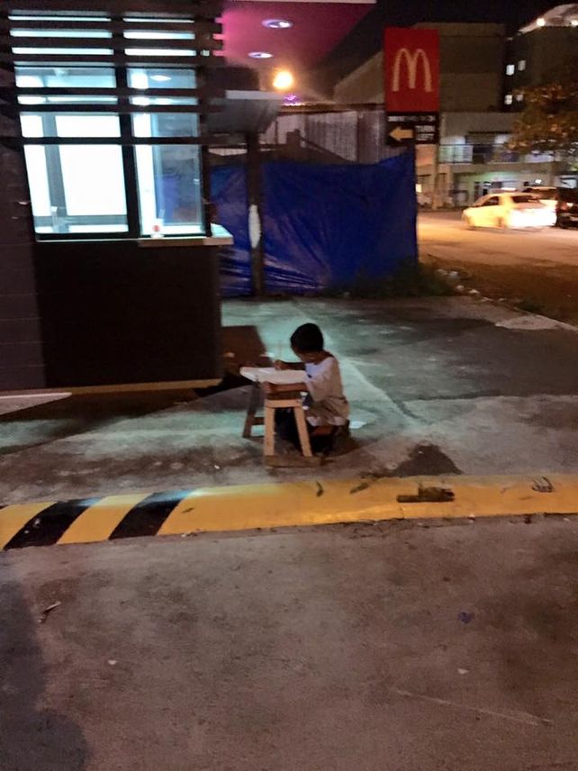 La foto de niño que estudia en la calle por falta de luz en su casa es viral