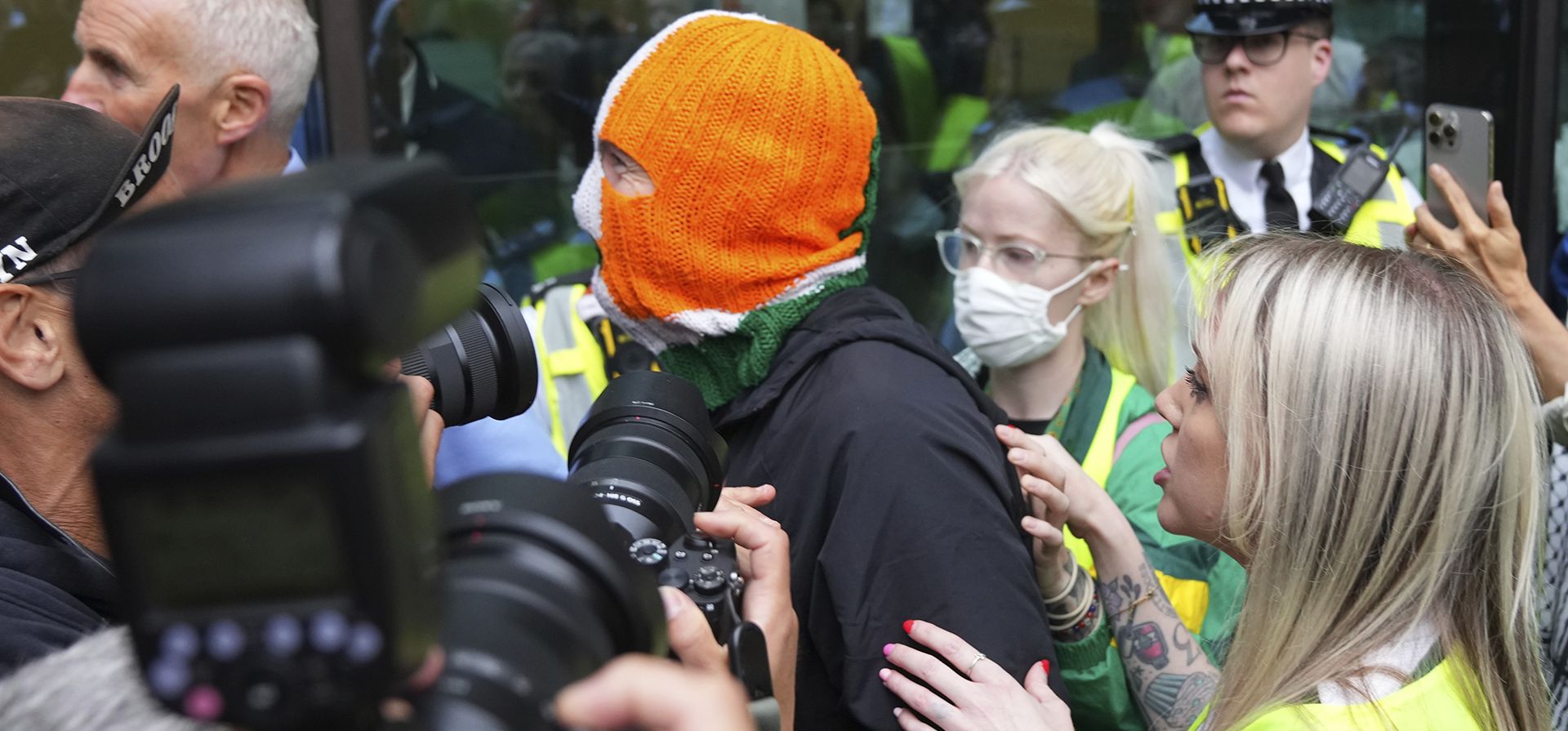 J. J. O. Dochartaigh, miembro de la banda irlandesa Kneecap, llega para apoyar a su compañero Liam Óg Ó hAnnaidh, también conocido como Mo Chara, en el Tribunal de Magistrados de Westminster, Londres, el miércoles 20 de agosto de 2025. Ó hAnnaidh está acusado de un delito de terrorismo por exhibir una bandera en apoyo a Hezbolá durante una actuación con la banda en noviembre de 2024. (Foto AP/Joanna Chan) J. J. O. Dochartaigh, miembro de la banda irlandesa Kneecap, llega para apoyar a su compañero Liam Óg Ó hAnnaidh, también conocido como Mo Chara, en el Tribunal de Magistrados de Westminster, Londres, el miércoles 20 de agosto de 2025. Ó hAnnaidh está acusado de un delito de terrorismo por exhibir una bandera en apoyo a Hezbolá durante una actuación con la banda en noviembre de 2024. (Foto AP/Joanna Chan)