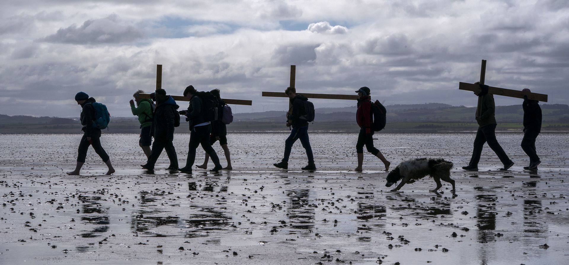 Peregrinos llevan cruces a la isla sagrada de Lindisfarne en Northumberland, Gran Bretaña, durante la peregrinación cristiana anual de Pascua el Viernes Santo, viernes 7 de abril de 2023. (Jane Barlow/PA vía AP)