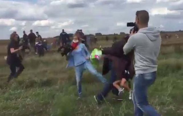 Las imagen muestra el momento en el que la camarógrafa le mete una traba a un hombre que llevaba en brazos a un niño.