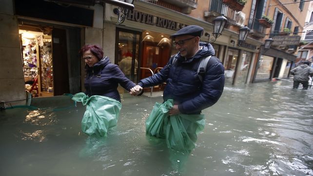 Una pareja vadea las calles inundadas del centro de Venecia