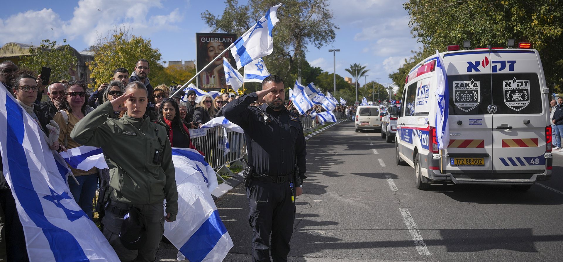 Una mujer y un policía fronterizos saludan mientras un convoy que transporta los ataúdes de cuatro rehenes israelíes, entre ellos una madre y sus dos hijos, llega al Instituto Forense Abu Kabir en Tel Aviv, Israel, el jueves 20 de febrero de 2025. Los cuerpos fueron entregados por grupos militantes palestinos en Gaza. (Foto AP/Ohad Zwigenberg) Una mujer y un policía fronterizos saludan mientras un convoy que transporta los ataúdes de cuatro rehenes israelíes, entre ellos una madre y sus dos hijos, llega al Instituto Forense Abu Kabir en Tel Aviv, Israel, el jueves 20 de febrero de 2025. Los cuerpos fueron entregados por grupos militantes palestinos en Gaza. (Foto AP/Ohad Zwigenberg)