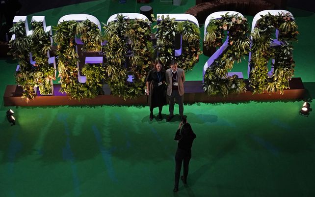 Una pareja posa para una foto en la Zona de Acción dentro de la sede de la Cumbre del Clima de la ONU COP26 en Glasgow, Escocia, el lunes 8 de noviembre de 2021. La cumbre del clima de la ONU en Glasgow está entrando en su segunda semana.