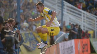 Marco ya convirtió y salta los carteles para festejar con los hinchas.