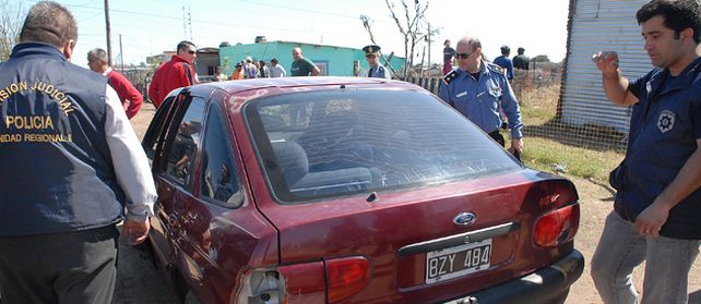 Los peritos de la policía trabajaron sobre el Ford Escort que manejaba su compañero antes de morir.