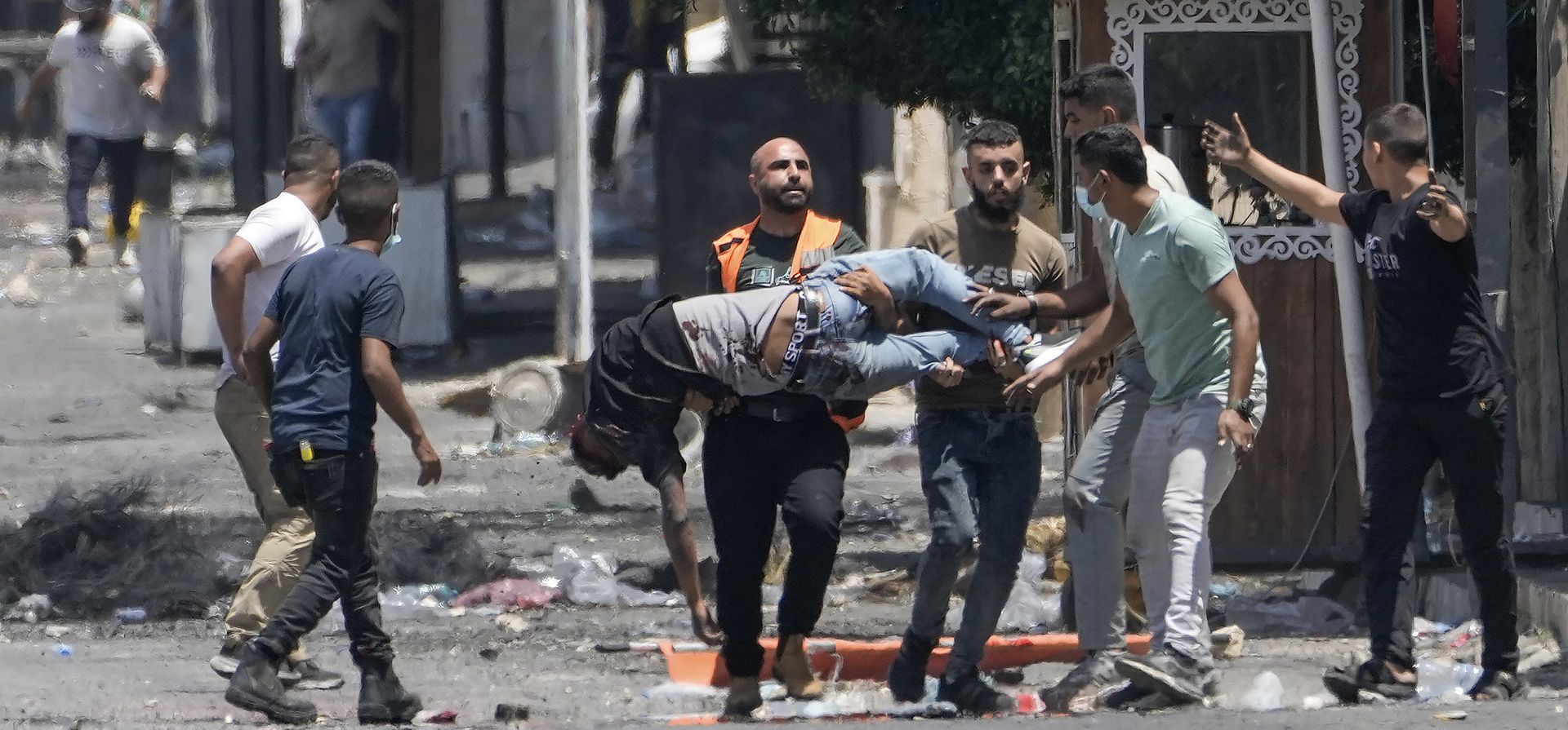 Palestinos cargan a un hombre herido por disparos israelíes, poco después de que lanzara una bomba contra un vehículo del ejército israelí, durante una redada militar en el campo de refugiados de Jenin, un bastión militante en la Cisjordania ocupada. (Foto AP/Majdi Mohamed) Palestinos cargan a un hombre herido por disparos israelíes, poco después de que lanzara una bomba contra un vehículo del ejército israelí, durante una redada militar en el campo de refugiados de Jenin, un bastión militante en la Cisjordania ocupada. (Foto AP/Majdi Mohamed)