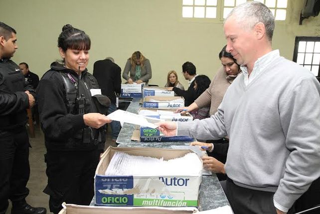 Agente policial retirando el sobre para realizar la votación.