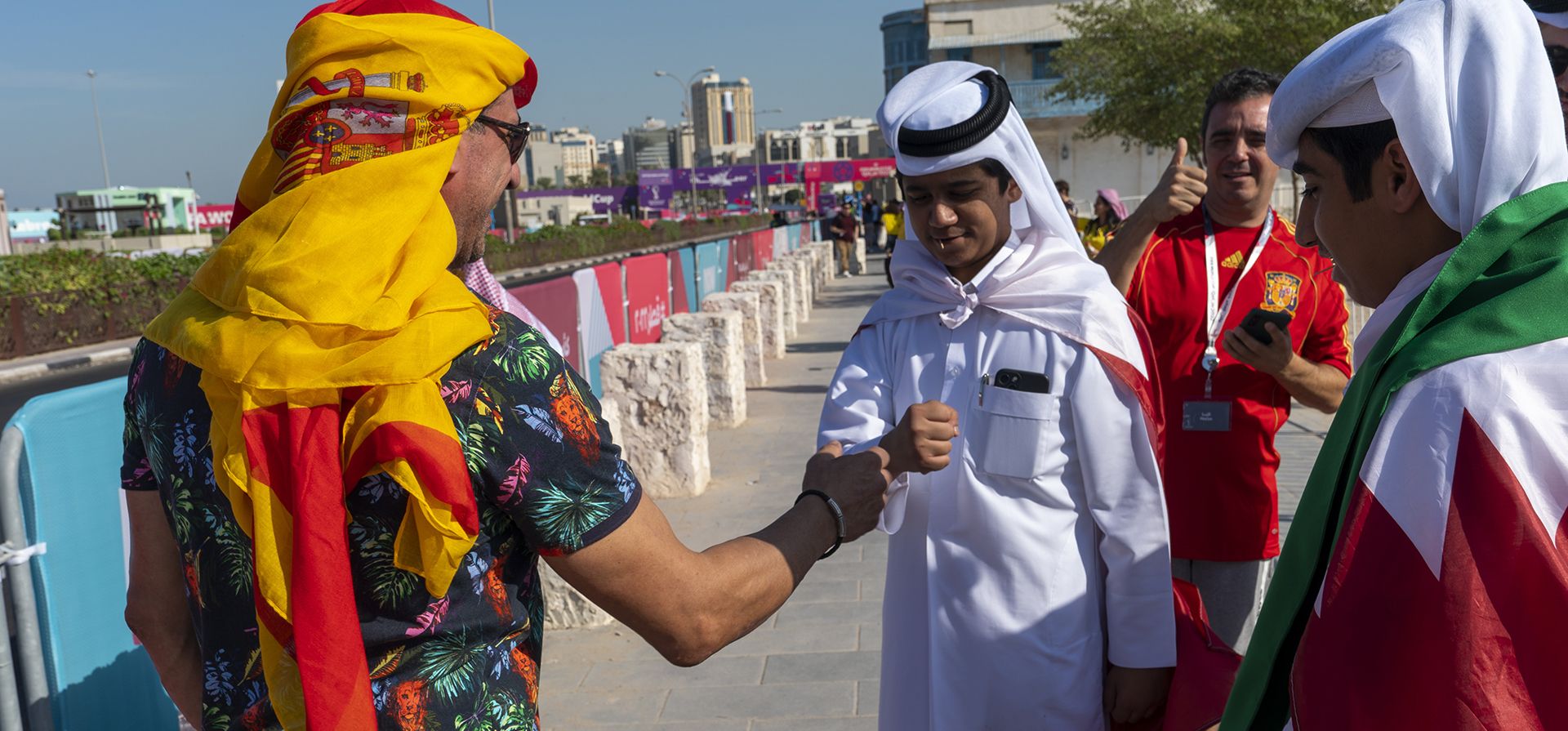 Un turista español choca su puño con un joven catarí en una calle cerca del mercado Souq Waqif en Doha, Qatar, el jueves 24 de noviembre de 2022. (Foto AP/Moises Castillo)