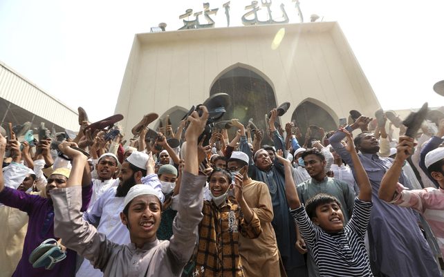 Un grupo de manifestantes grita consignas y agita zapatos después de las oraciones del viernes en la mezquita Baitul Mokarram en Dhaka