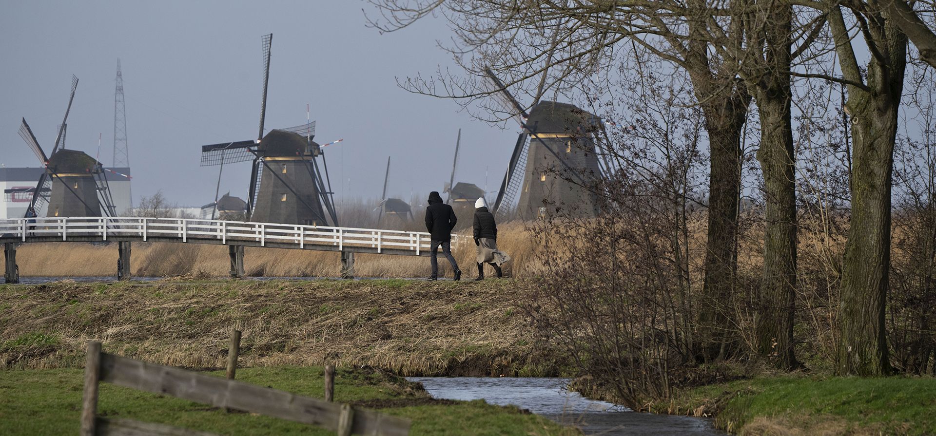 Dos personas desafían el viento mientras caminan junto a los icónicos molinos de viento del siglo XVIII que forman parte de la red tradicional de gestión del agua en el sitio del patrimonio mundial de la UNESCO en Kinderdijk, Países Bajos, el miércoles 24 de enero de 2024. (Foto AP/Peter Dejong) Dos personas desafían el viento mientras caminan junto a los icónicos molinos de viento del siglo XVIII que forman parte de la red tradicional de gestión del agua en el sitio del patrimonio mundial de la UNESCO en Kinderdijk, Países Bajos, el miércoles 24 de enero de 2024. (Foto AP/Peter Dejong)