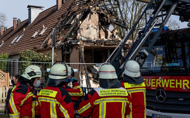 Bomberos reunidos frente a una casa que está casi completamente destruida después de que ocurriera una explosión en el condominio que dejó a una residente de 54 años desaparecida.