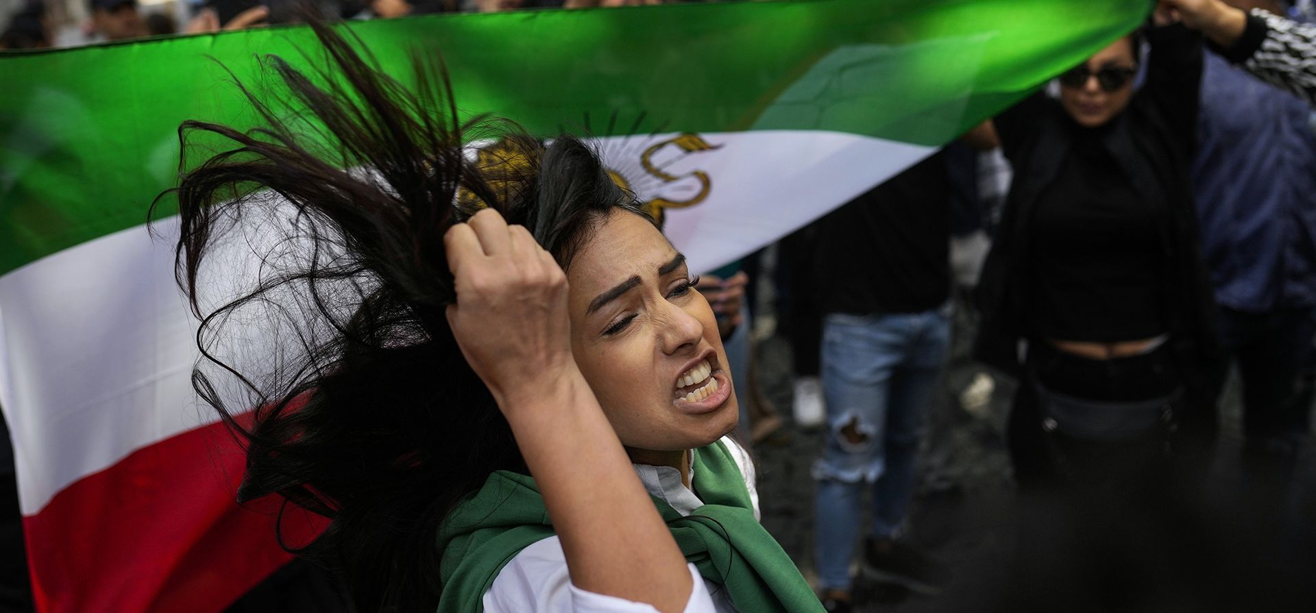 Una mujer grita consignas junto a una bandera iraní durante una protesta contra la muerte de la iraní Mahsa Amini, frente al consulado general de Irán en Estambul, Turquía, el miércoles 21 de septiembre de 2022. Las protestas estallaron en todo Irán en los últimos días después de que Amini, una mujer de 22 años -años de edad, murió mientras estaba detenida por la policía moral por violar el estricto código de vestimenta islámico del país.